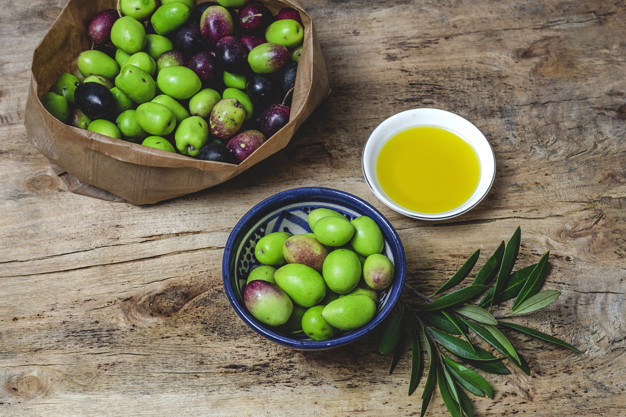Fresh Spanish extra virgin olive oil with olives and old olive branch. Healthy food Mediterranean diet. Vegan. Vegetarian